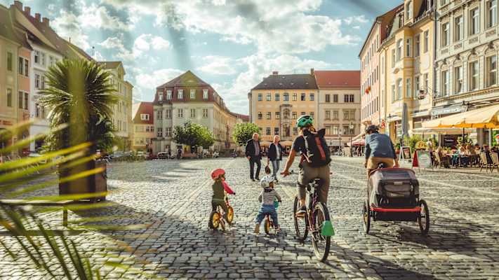 Eine radfahrende Familie fährt durch die Altstadt von Zittau.
