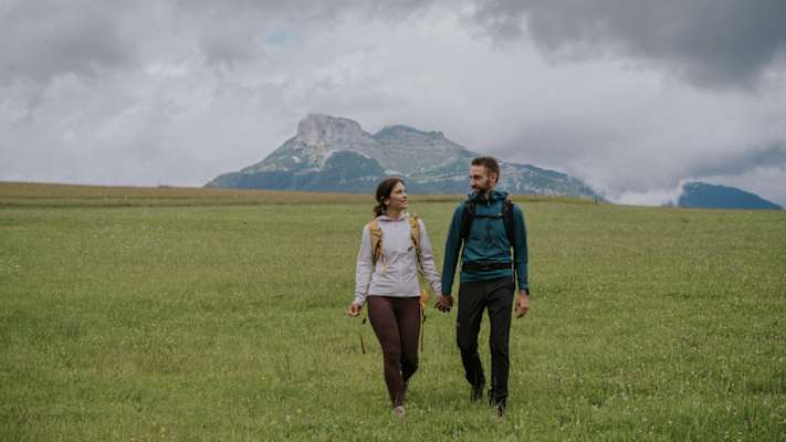 Zwei Wanderer auf einer Almwiese im Salzkammergut, im Hintergrund sieht man den Loser.