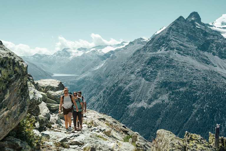 Zwei Frauen und ein Mann wandern auf dem Almageller Höhenweg.