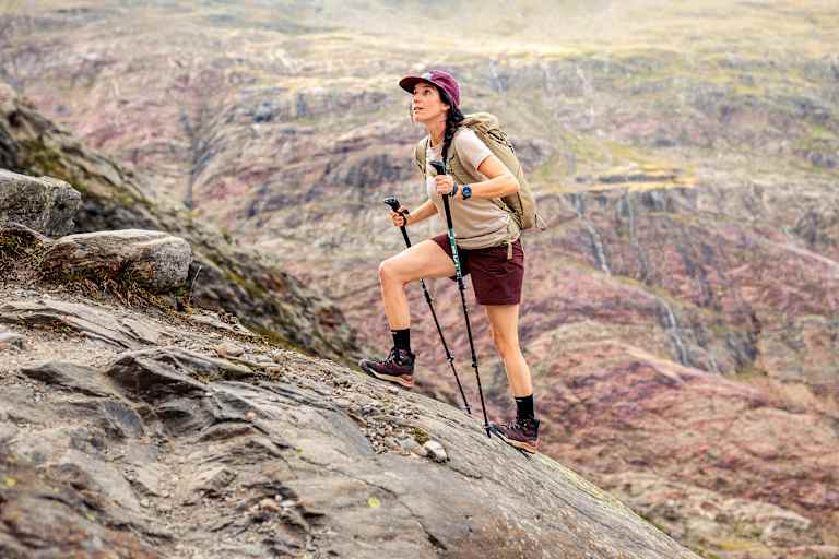 Eine Outdoor-Enthusiastin geht einen Fels hoch und trägt dabei den den LOWA® EXPLORER GTX MID Ws.