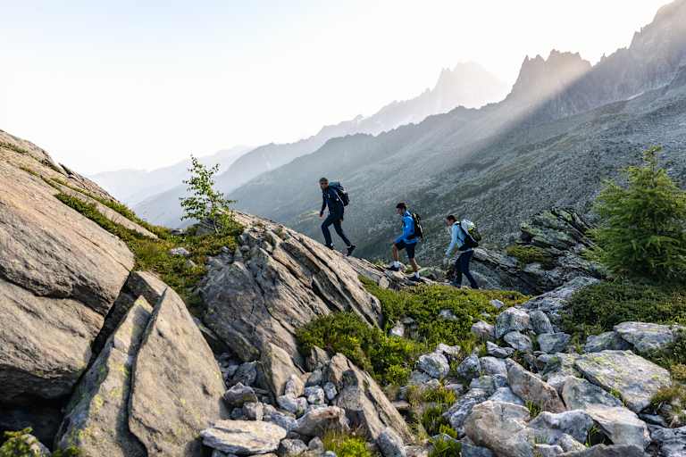 Zwei Männer und eine Frau gehen eine Tour auf einem panoramareichen Weg und tragen dabei den Ducan III Low LTH GTX.