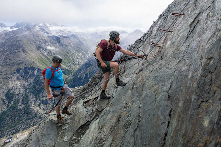 Zwei Kletterer steigen auf den Mittaghorn Klettersteig im Saastal.