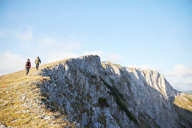 Zwei Wanderer gehen über das herbstliche Raxplateau