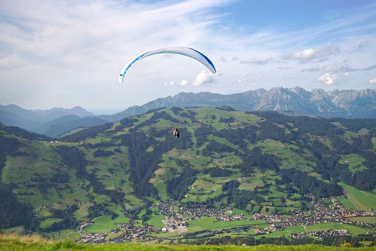 Paragleiter über dem Brixental mit Blick auf den Wilden Kaiser
