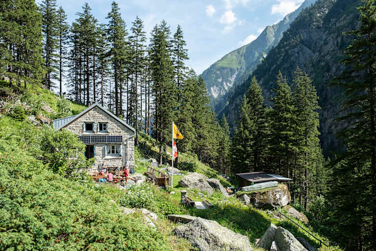 gemütliche Berghütte aus Stein umgeben von Wald