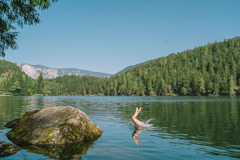 Eine Person springt in den Pitburger See in Tirol