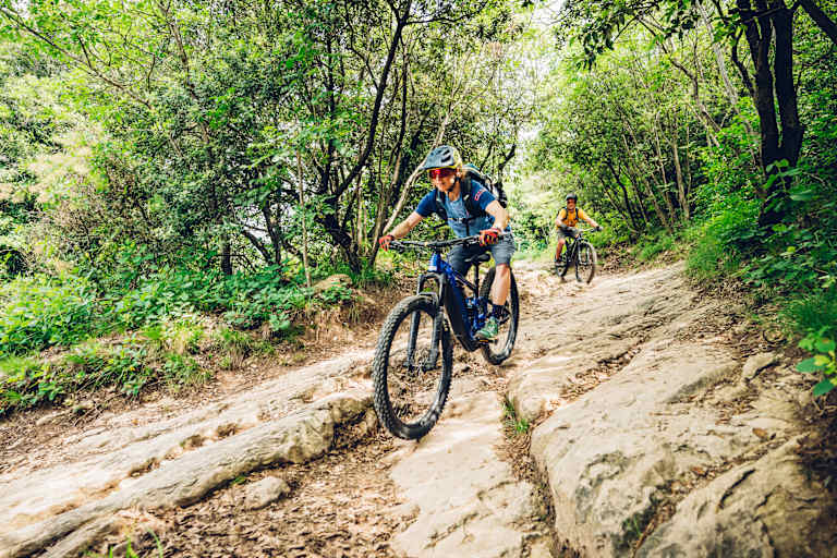 Frau fährt auf einem Mountainbike bergab