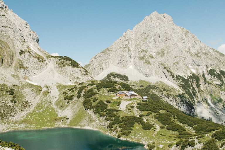 Wanderer am Drachensee in Tirol - im Hintergrund die Coburger Hütte.