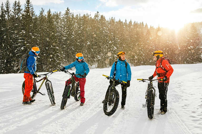 Die Fatbike-Gruppe bei strahlendem Sonneschein im Schnee.