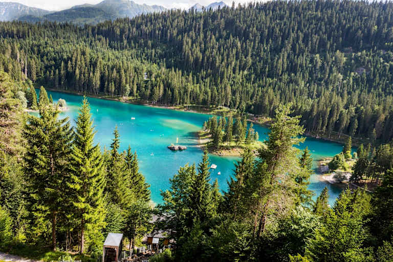 Ein See umgebene von Wäldern.