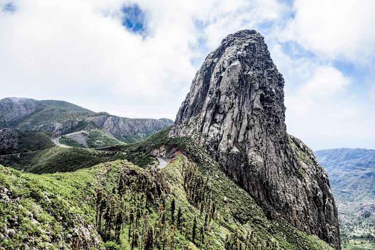 Ein Felsturm eingebettet in satten Grün