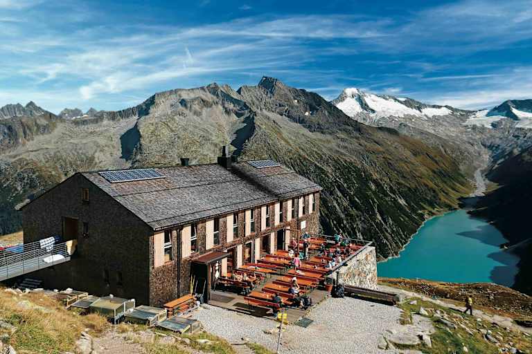 Die Olpererhütte besitzt einen Logenplatz über dem Schlegeis-Stausee. Dahinter Greinerkamm und der vergletscherte Möseler.