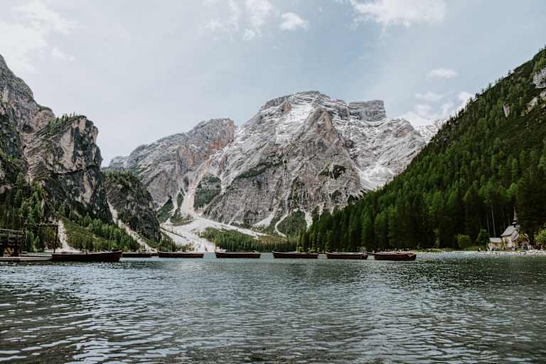 Pragser Wildsee mit Seekofel und Booten auf dem Wasser.