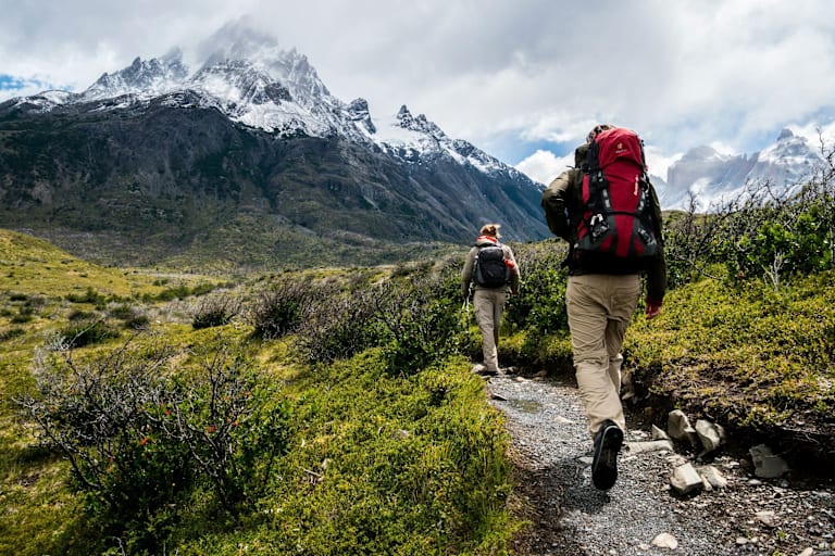 Zwei Personen gehen in der Natur wandern.
