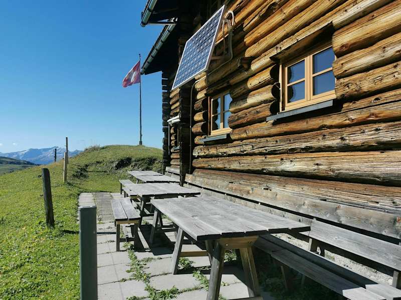 Gemütliche Sitzgelegenheit an der Holzwand des Naturfreundehauses Medergerfluh.