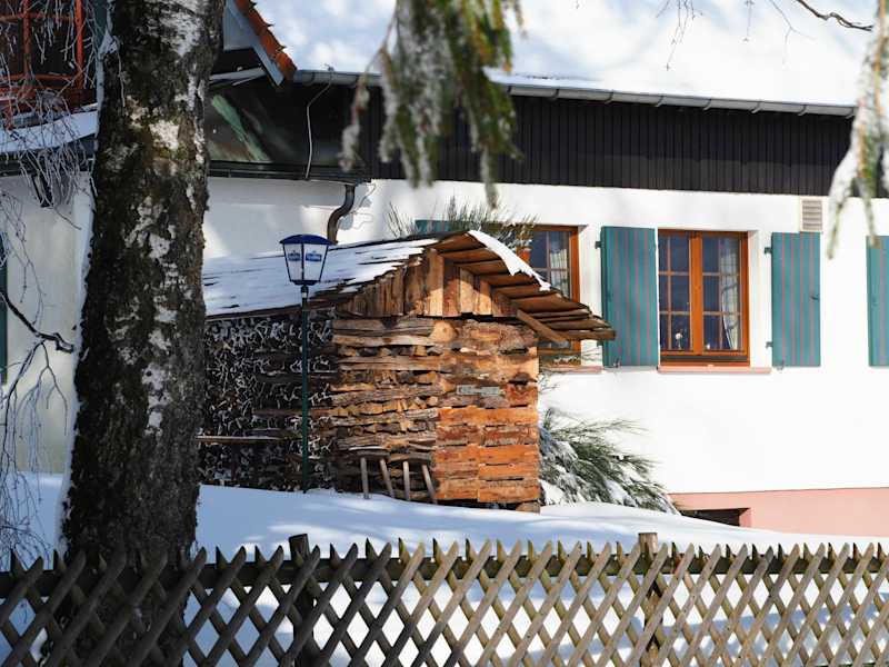 Die Wintersonne wärmt den Holzstapel beim Wanderheim Kreuzmoos