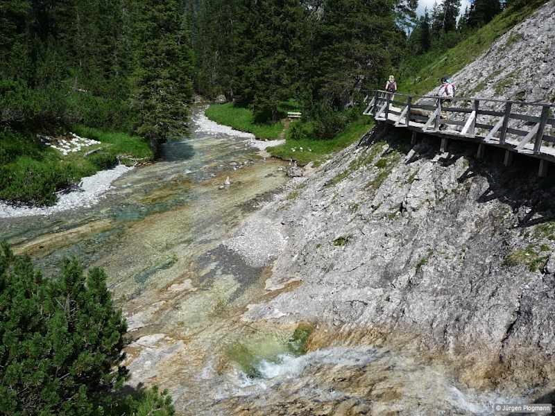 Sehr aufwendig angelegte Holzbrücken und -stege ermöglichen einen beschwingten und erlebnisreichen Gang über den Wassern des Baches.