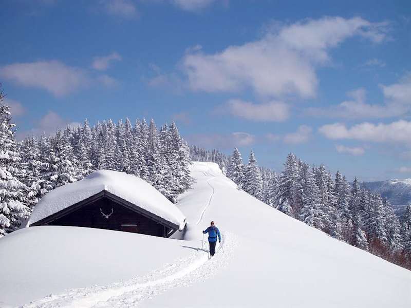 Verschneite Holzhütte entlang des Aufstiegs