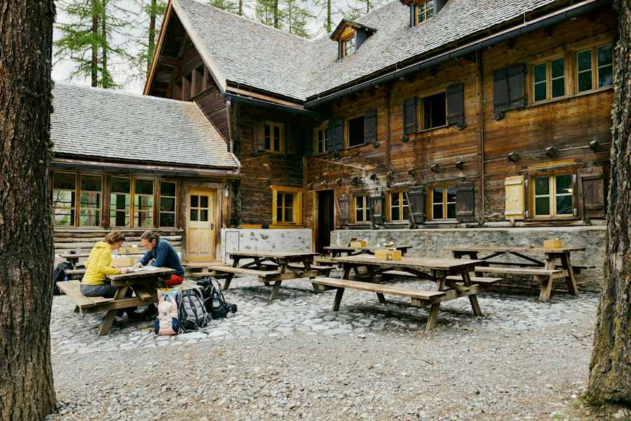 Die Chamanna Cluozza auf 1.882 Meter Seehöhe (oben) ist die einzige bewirtschaftete Hütte im Schweizerischen Nationalpark. Dort werden Nachhaltigkeit und Regionalität vor allem seit dem Umbau vor drei Jahren sehr ernst genommen: Das gilt für natürliche Baumaterialien wie Kalk und Stampflehm, die 30.000 Lärchenschindeln – und die Zutaten für die Speisen, etwa Alpentapas und Zwetschkenkuchen (unten).