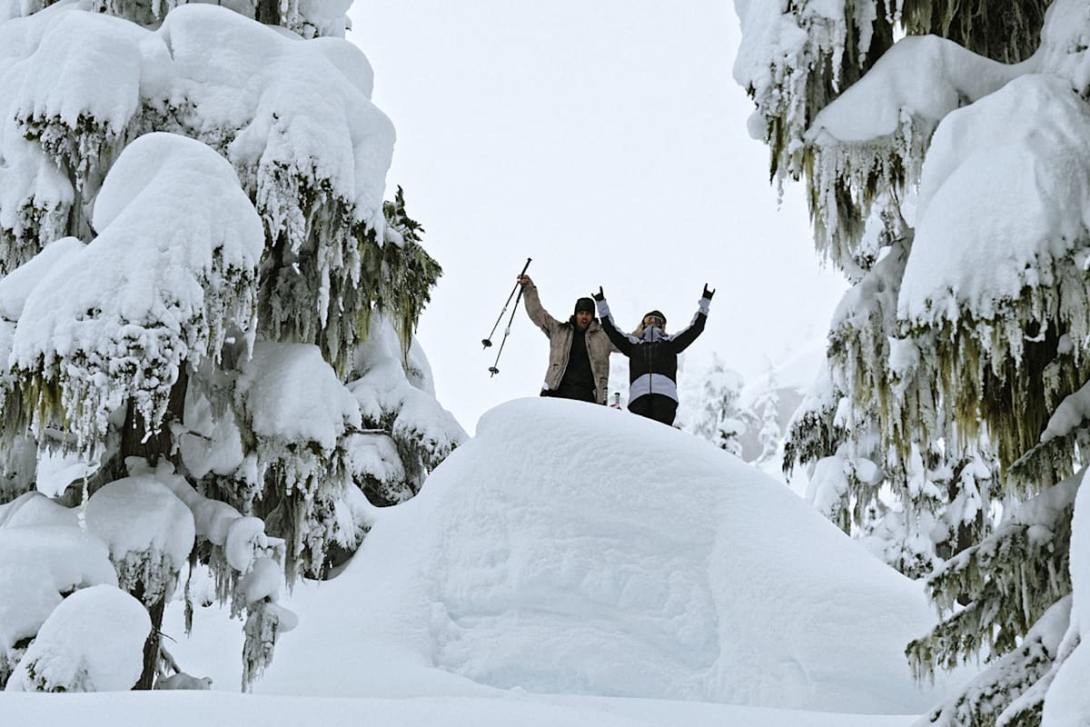 Zwei Personen im Schnee in Japan mit Skiausrüstung.