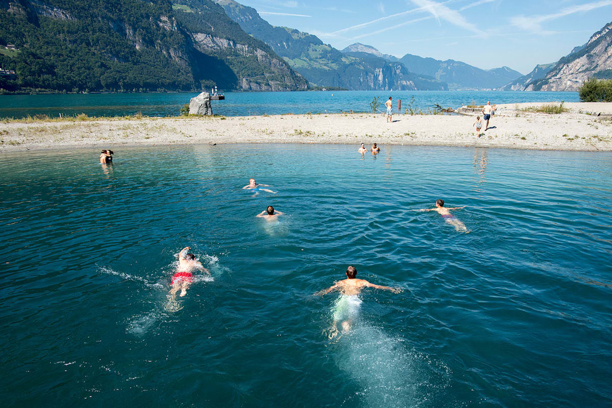 Eine Gruppe von Personen schwimmen in einem blauen See.