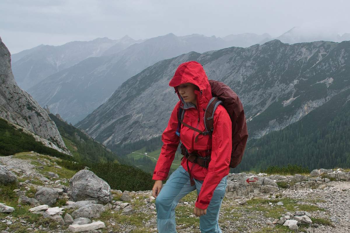 Bergsteiger mit roter Jacke bei schlechtem Wetter