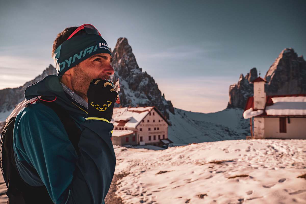 Jakob Herrmann gönnt sich einen Snack während dem AlpFrontTrail in den Südtiroler Dolomiten, die Drei Zinnen im Hintergrund