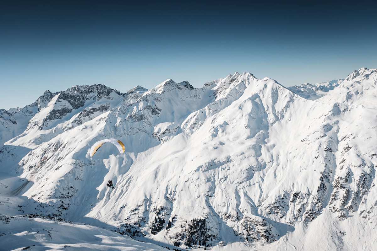 Lautlos und elegant geht es mit dem Paragleiter über das Moostal, zu unberührten Hängen und grandiosen Abfahrten.