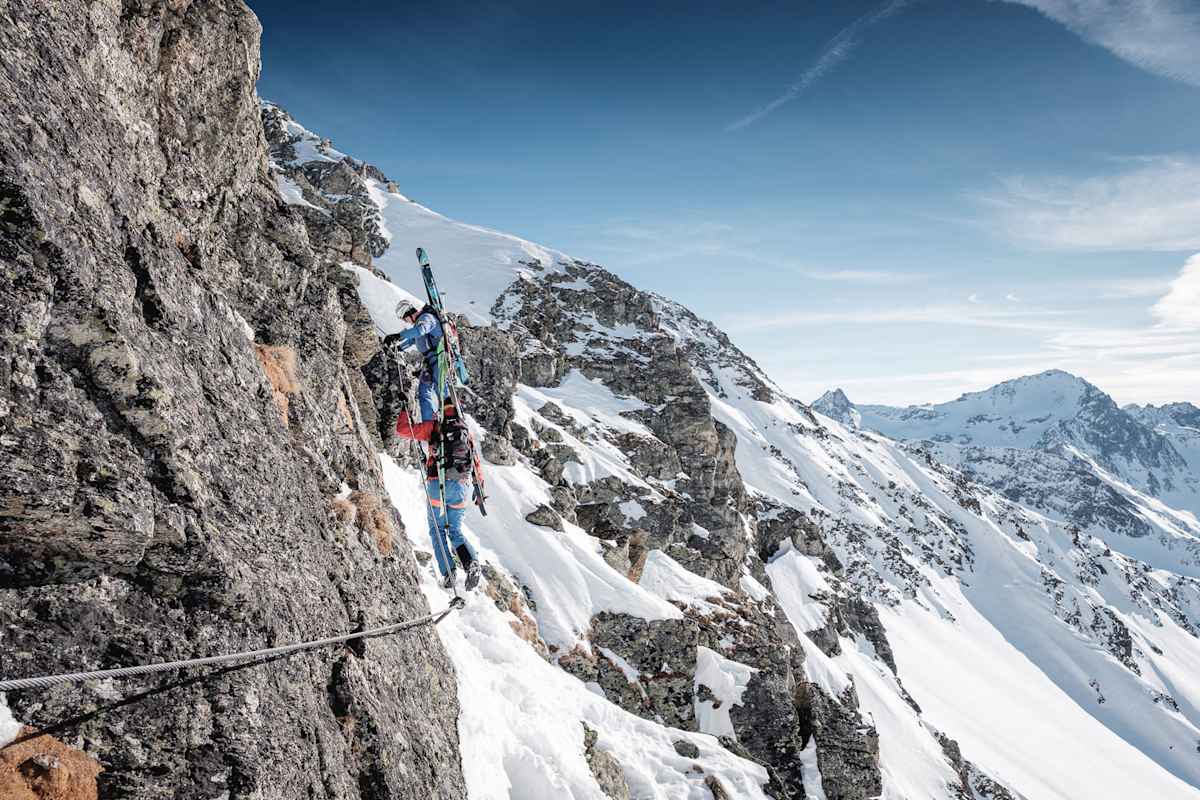 Ein Stahlseil in Fels und Schnee: Mit Skiern am Rücken und Skischuhen an den Füßen geht es am Arlberger Winterklettersteig am Rendl in Richtung Rossfallscharte.