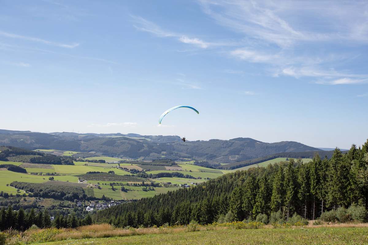 Ein Gleitschirmflieger startet vom Istenberg.