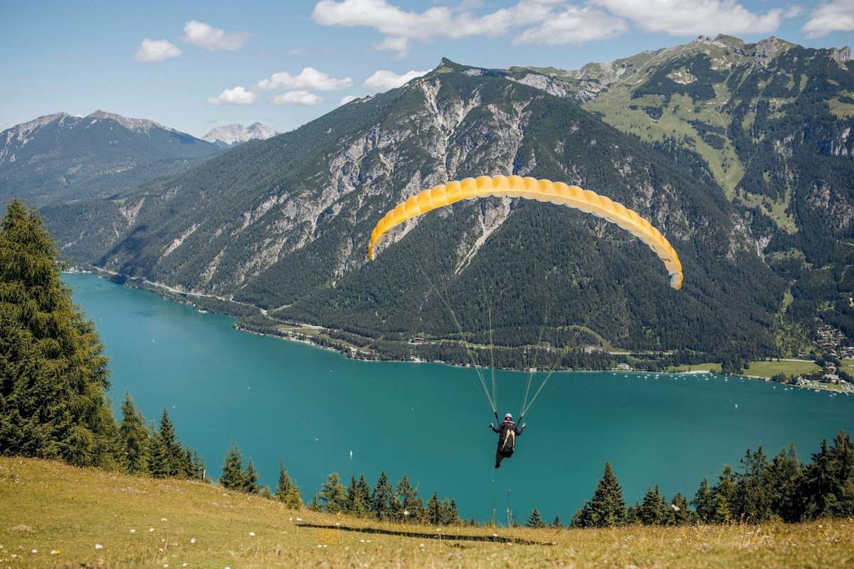 Ein Paragleiter startet über den Achensee hinaus