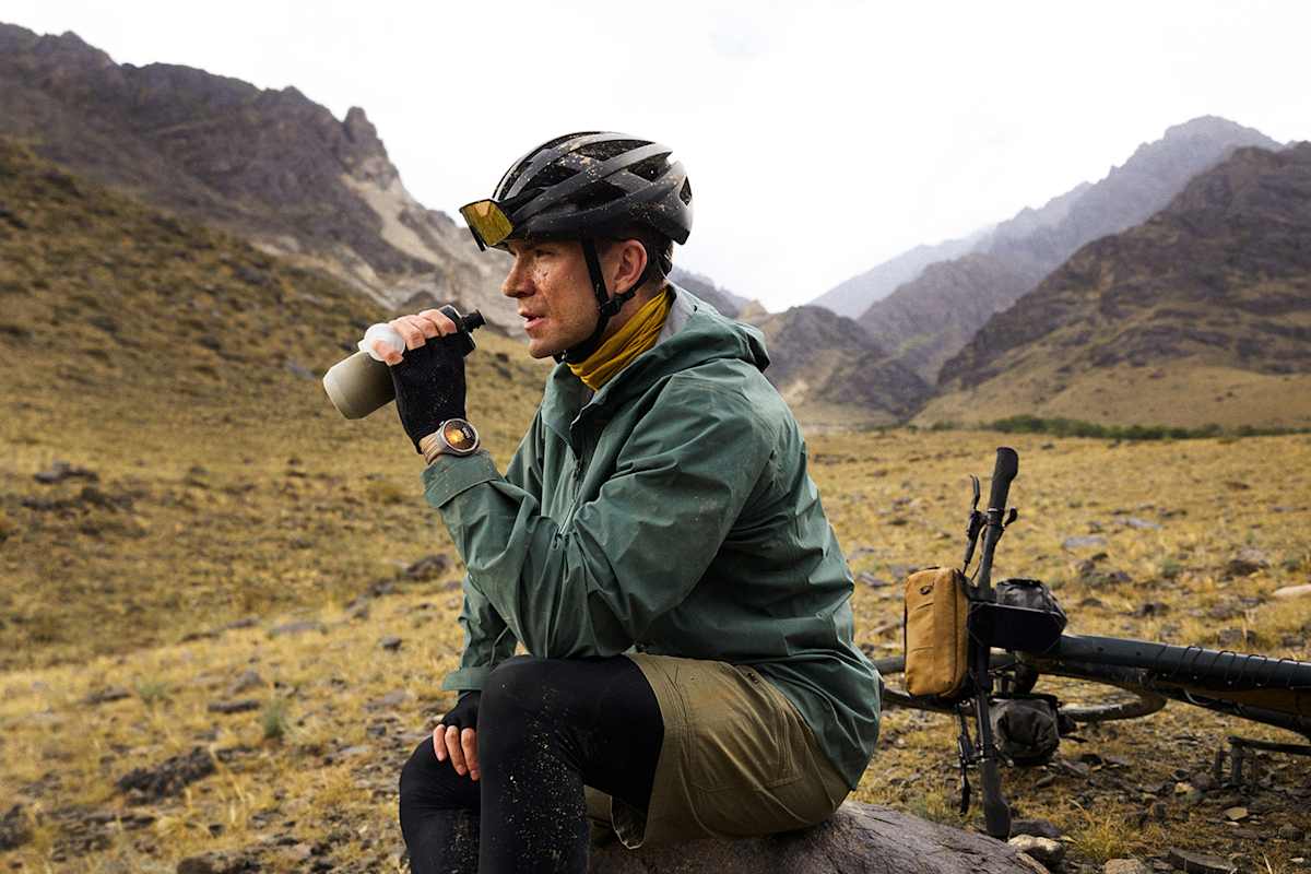 Mountainbiker mit HUAWEI WATCH GT 6 trinkt Wasser bei einer Pause im Gebirge – robuste Smartwatch für Sport und Natur.