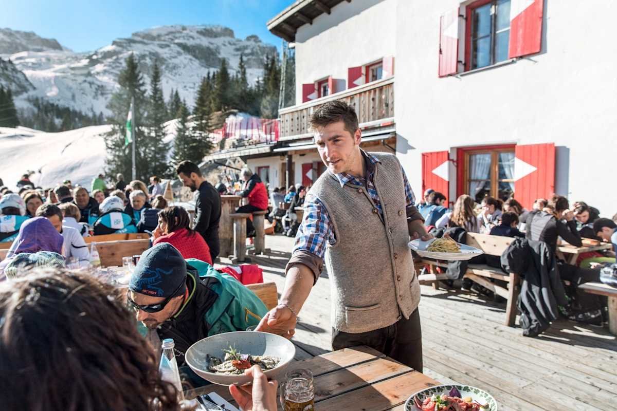 Ein Kellner serviert die Hauptspeise.