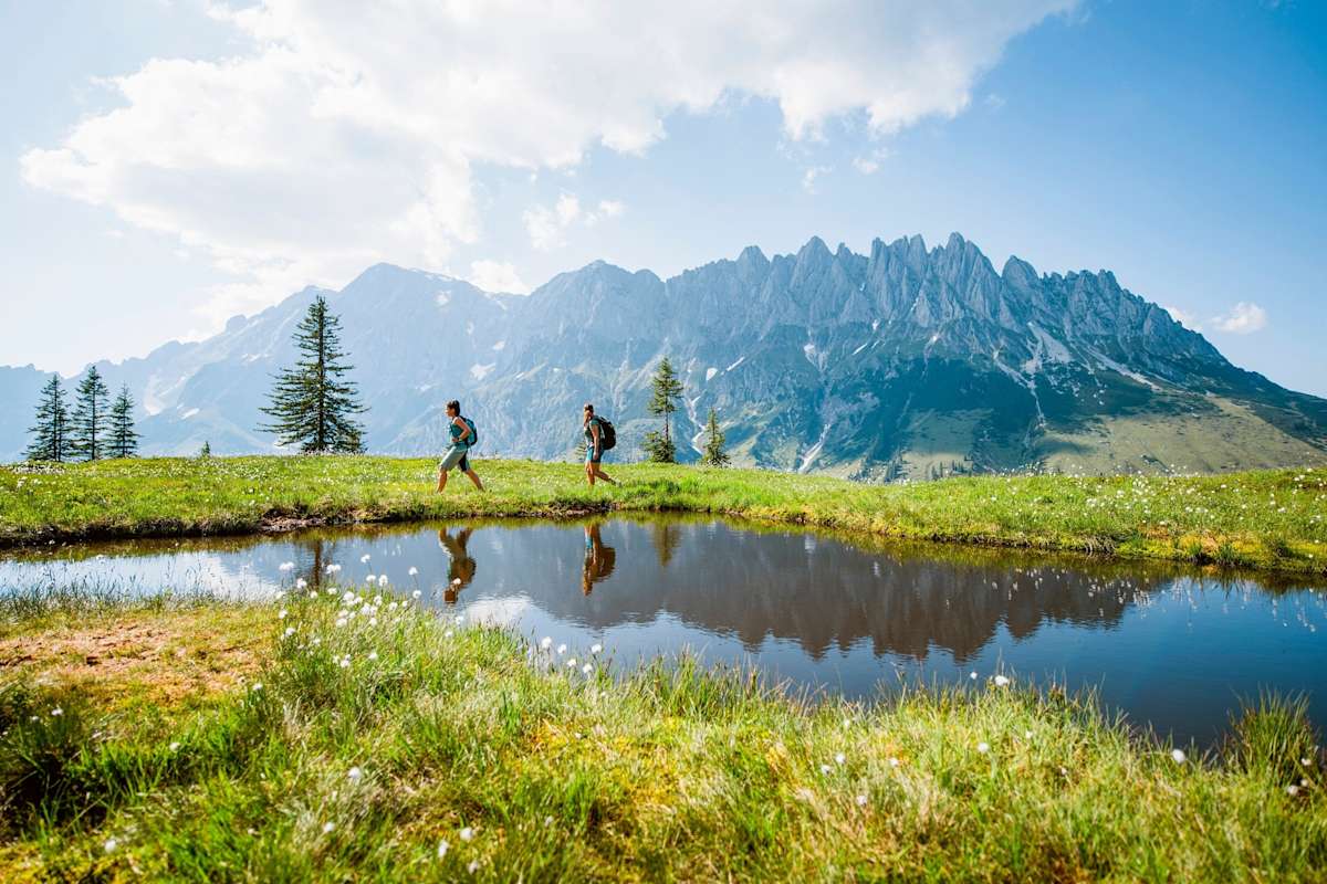 Bergsteiger wandern entlang eines kleines Bergsees.