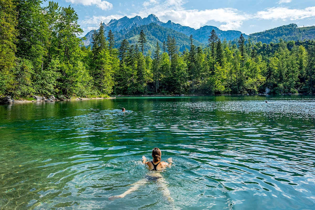 Eine Frau schwimmt im Bergsee.