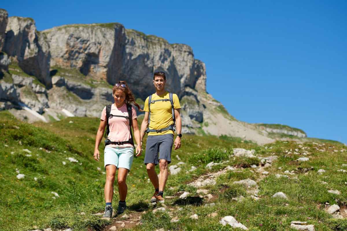 Zwei Wanderer im Abstieg vor einem Berg.