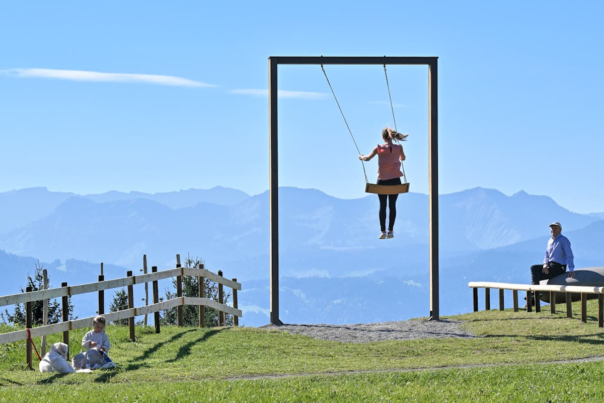 Eine Frau schaukelt auf einem Berg.