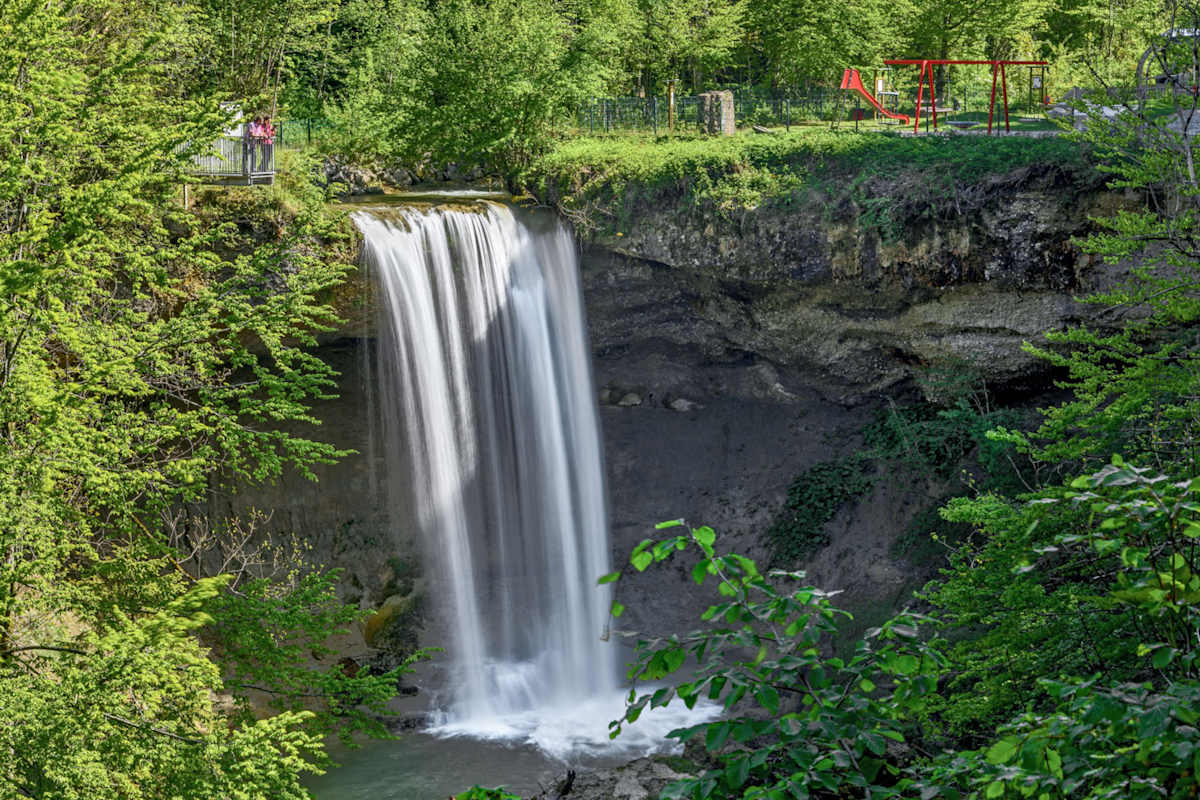 Zwei Menschen schauen auf einen großen Wasserfall
