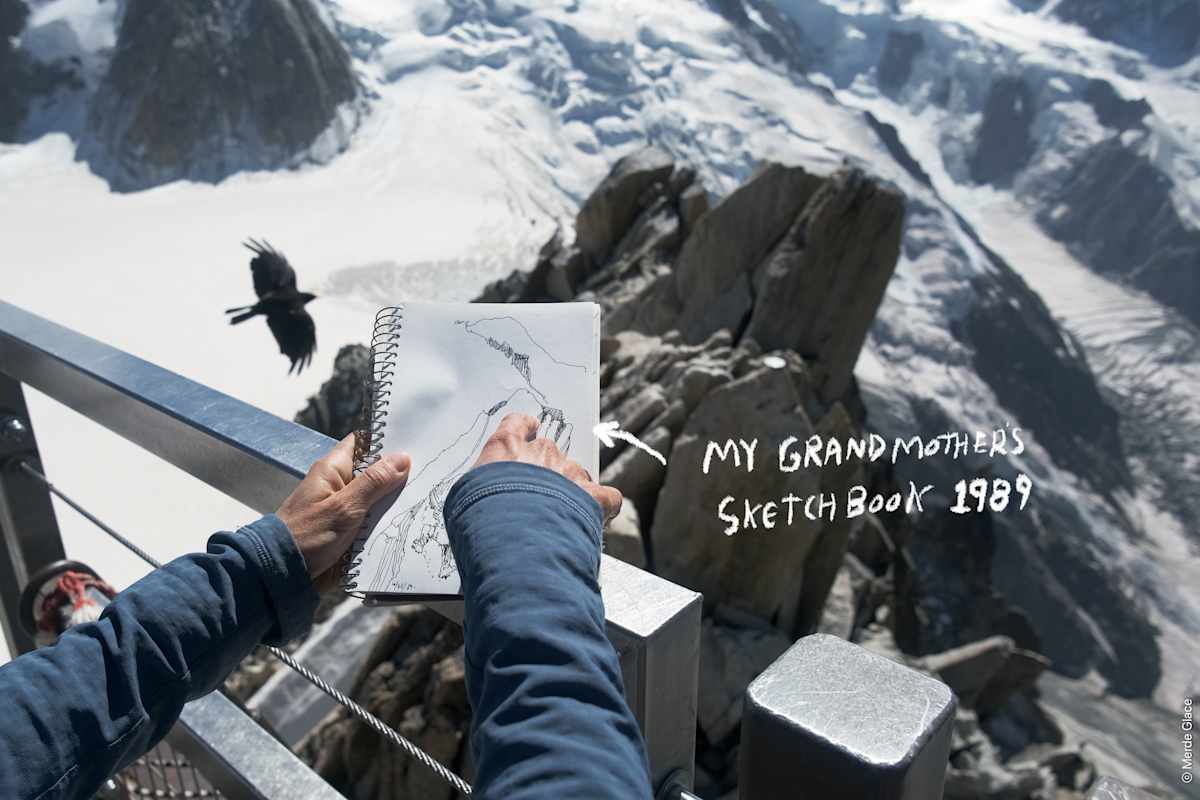 Ein Mann zeigt auf eine Skizze in seinem Notizbuch vor einer winterlichen Kulisse.