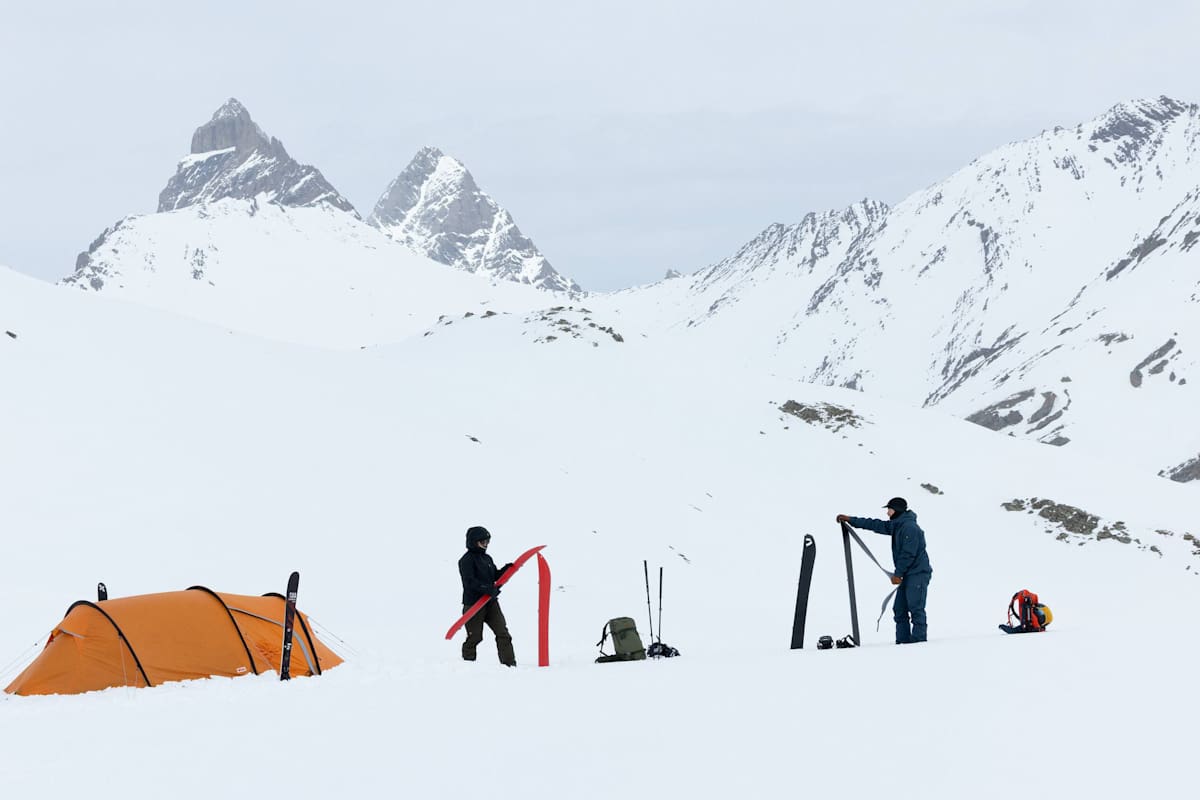 Drei Personen sind mit der neuen Bertagen-Kollektion von Fjällräven ausgerüstest und bereiten ihre Skitouren-Ausrüstung auf.