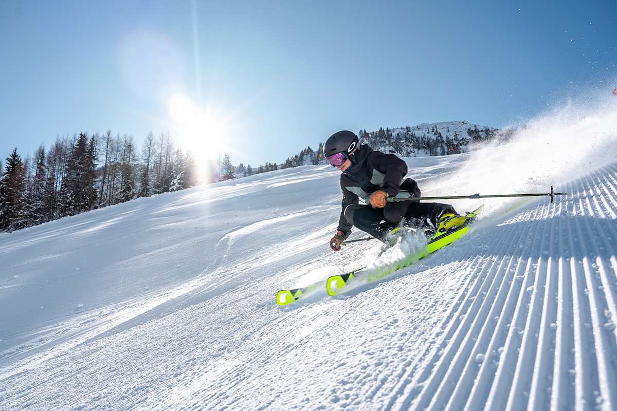 Eine Skifahrerin fährt eine perfekt präparierte Piste im Skicircus Saalbach-Hinterglemm-Leogang-Fieberbrunn.