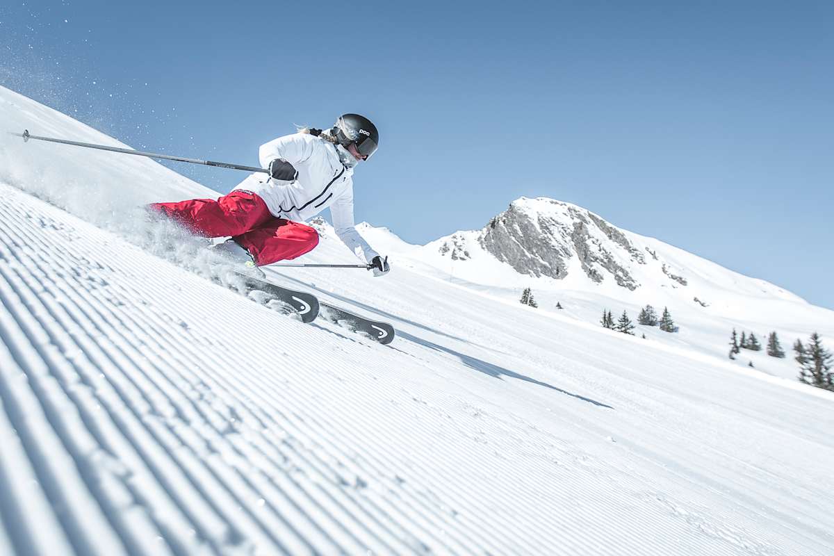 Eine Skifahrerin fährt eine perfekt präparierte Piste hinunter.