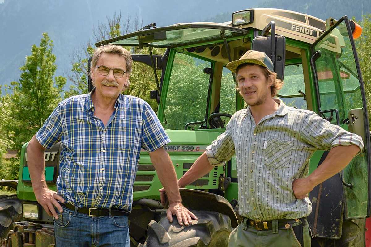 Die Kräuterbauern Reto und Fabrizio vor dem Traktor.