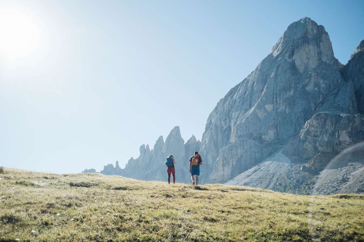 Zwei Kletterer unterwegs vor sonnigem Panorama.