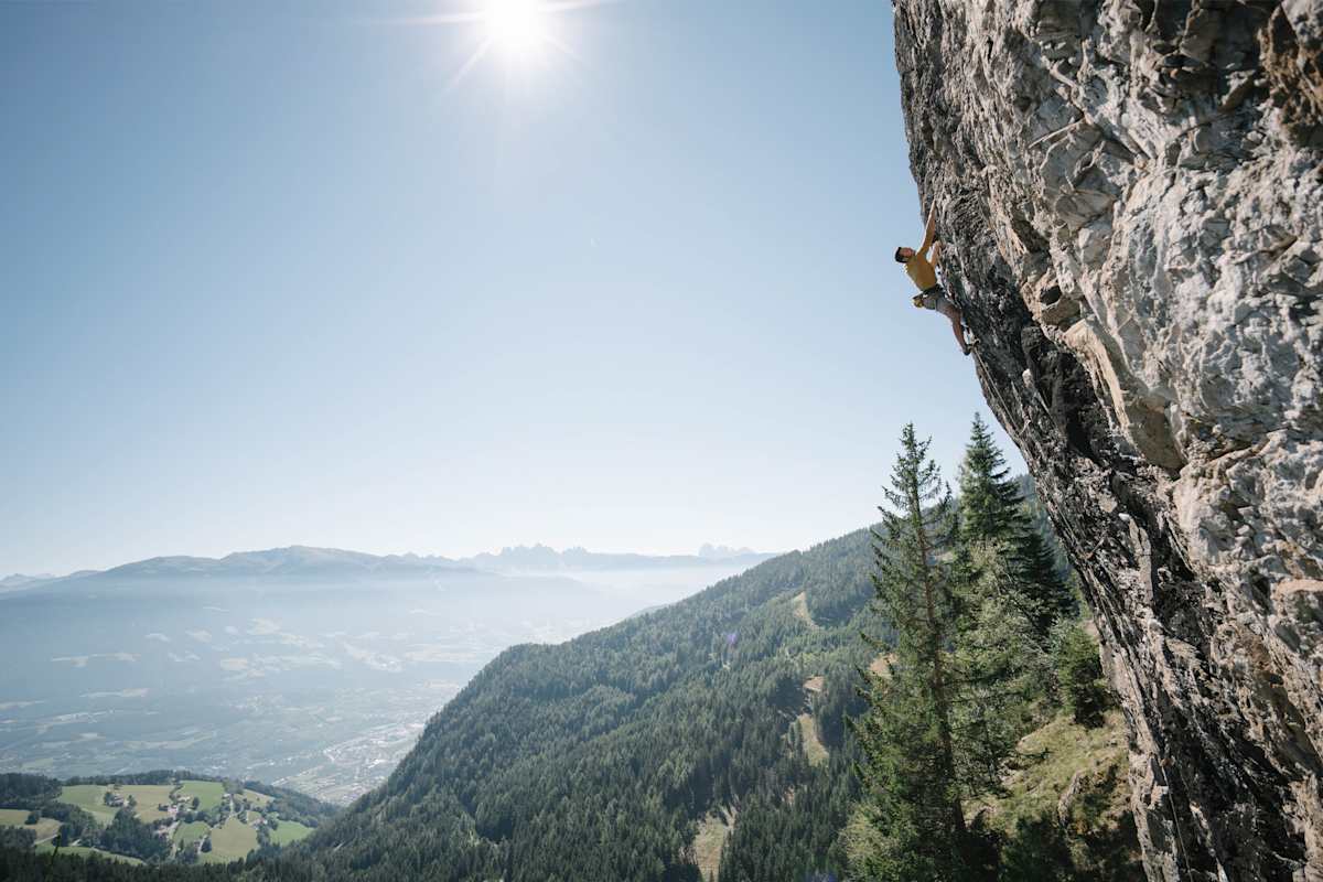 Atemberaubendes Panorama, davor ein Mann in der Felswand.