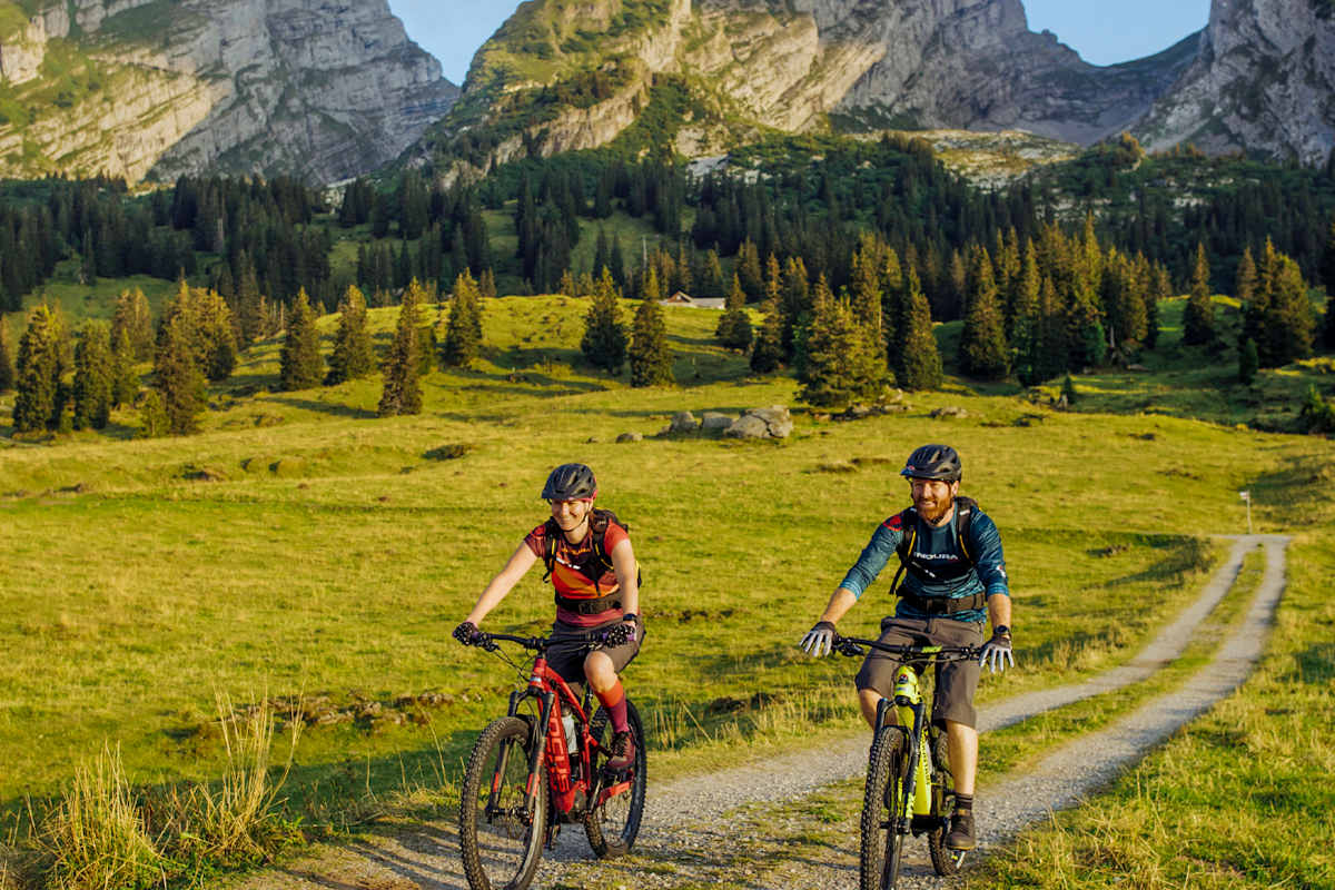 Zwei Radfahrer treten den Berg hinauf.