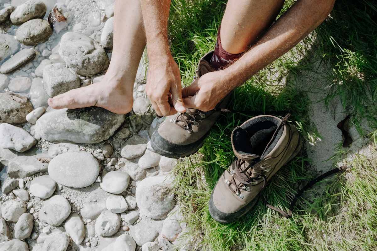 Close-Up einer Person, die Wanderschuhe anzieht