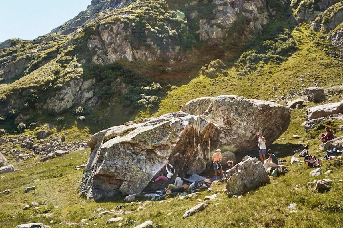 Boulderer stehen rund um den Fels.