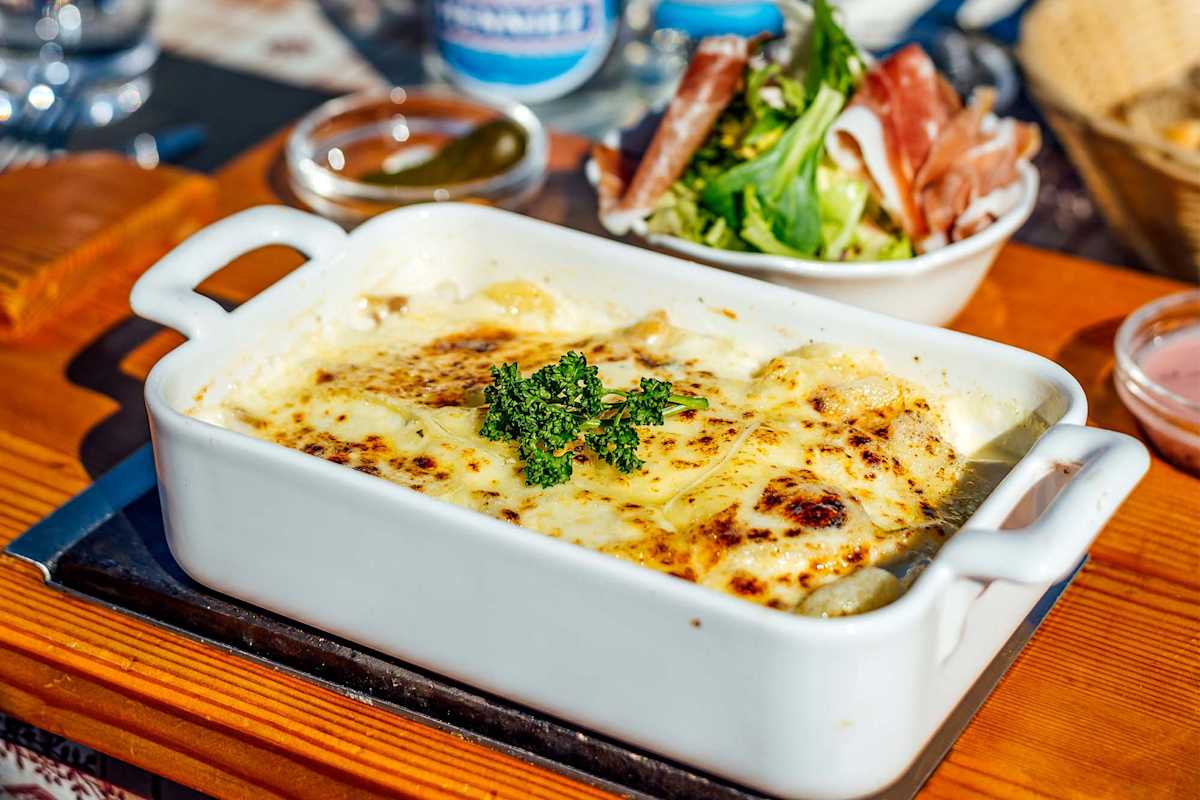 Das Käsegericht wird mit frischen Kräutern serviert.