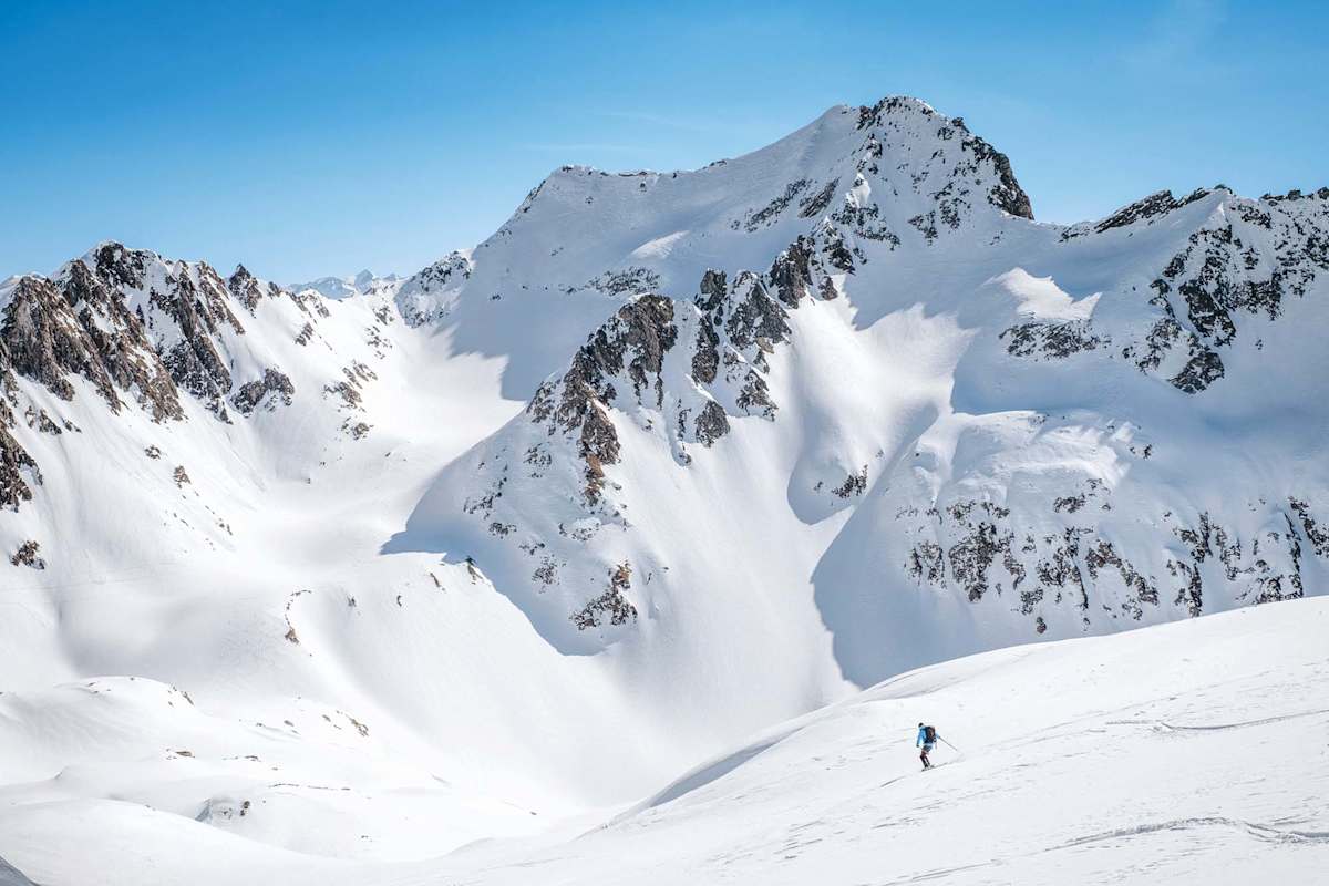 Ein Skifahrer bei der Abfahrt, dahinter der Cristallinagipfel.